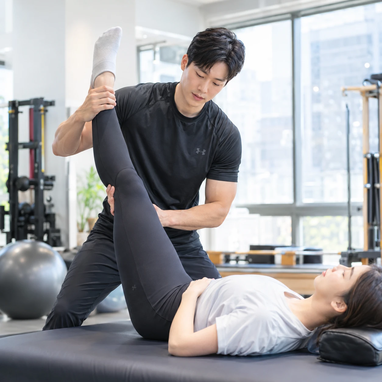 트레이너가 회원의 스트레칭을 도와주는 모습